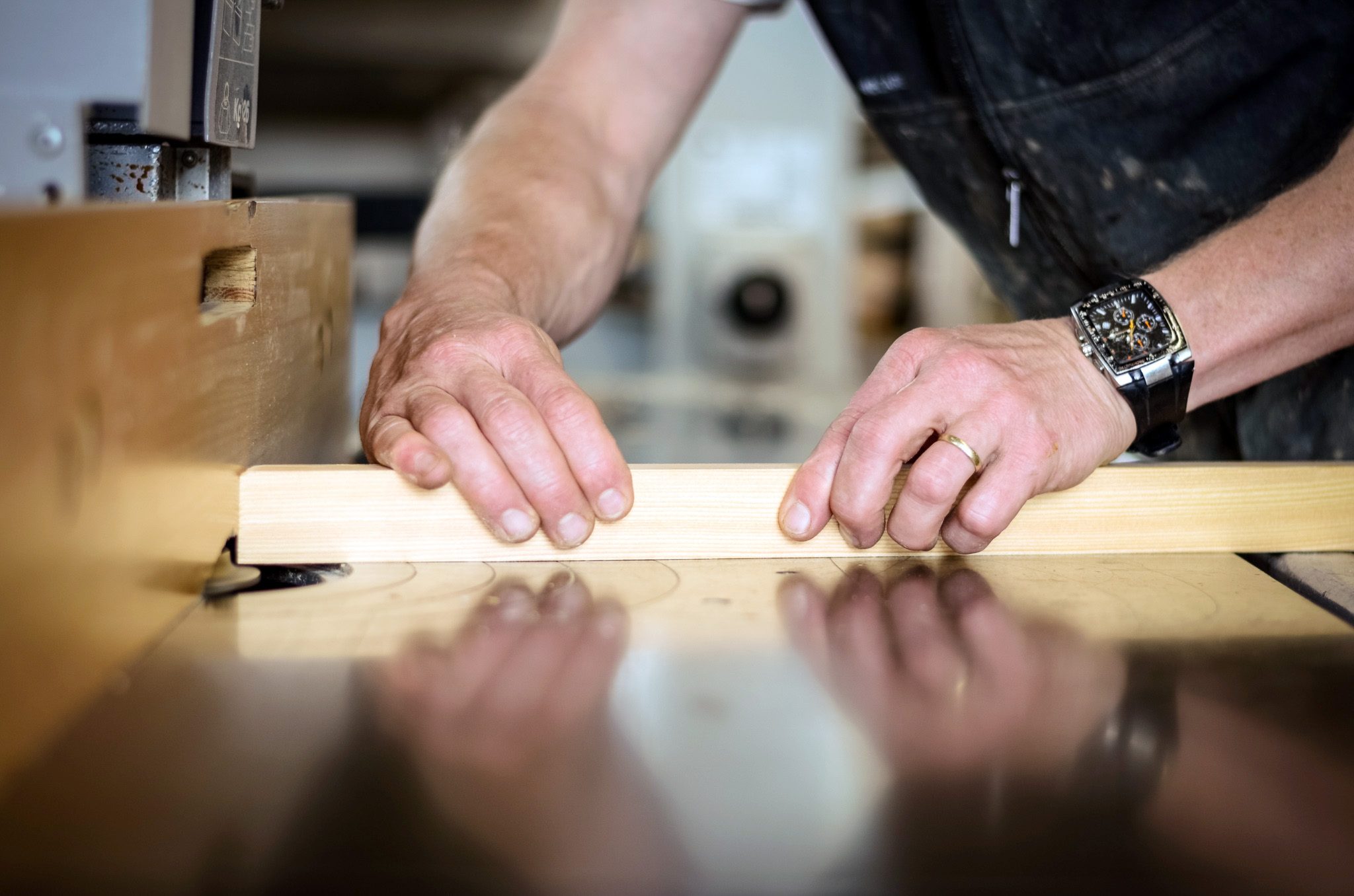 Handwerker prüft ein Holzbauteil an der Werkbank
