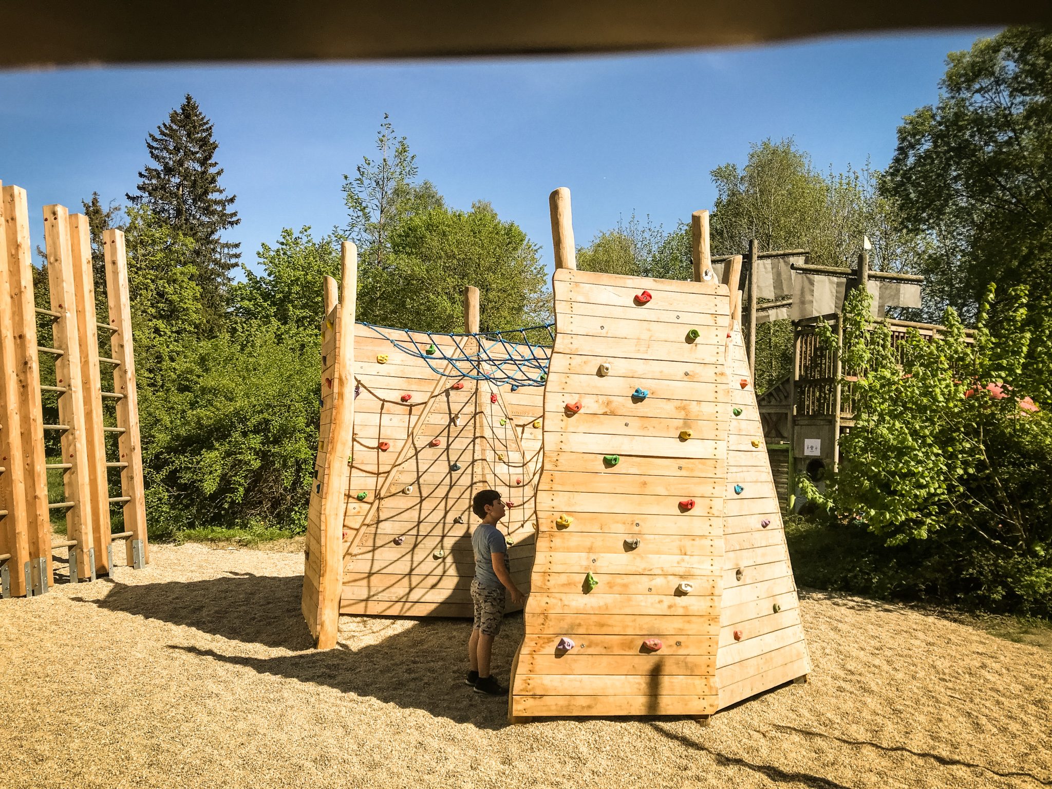 Kletterwand und Kletternetz aus Holz mit Kind im Netz